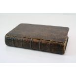 An antique leather bound book made into hidden compartment storage box.