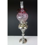 A silver plated oil lamp of classical form with drop in well Hinks burner and a cranberry floral