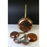Set of Four Copper Graduating Frying Pans with Brass Handles, largest 16cms diameter together with a