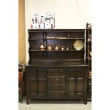 Ercol Dark Elm Dresser with Plate Rack above a bank of four drawers flanked by two cupboards, 144cms