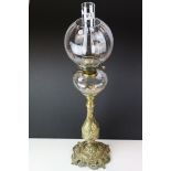 An antique brass French oil lamp of classical form with clear glass well shade and chimney.