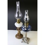 An Art Nouveau style oil lamp with scrolling base raised on a reeded column with blue glass well and