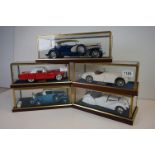 Five cased 1:18 scale diecast model classic cars to include BMW, Jaguar etc, models fixed to a
