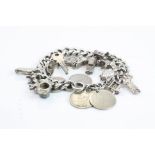 Silver curb link charm bracelet, with 13 silver and white metal charms and 4 coin charms