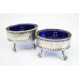Pair of George III silver pierced open oval salt cellars raised on four ball and claw feet,