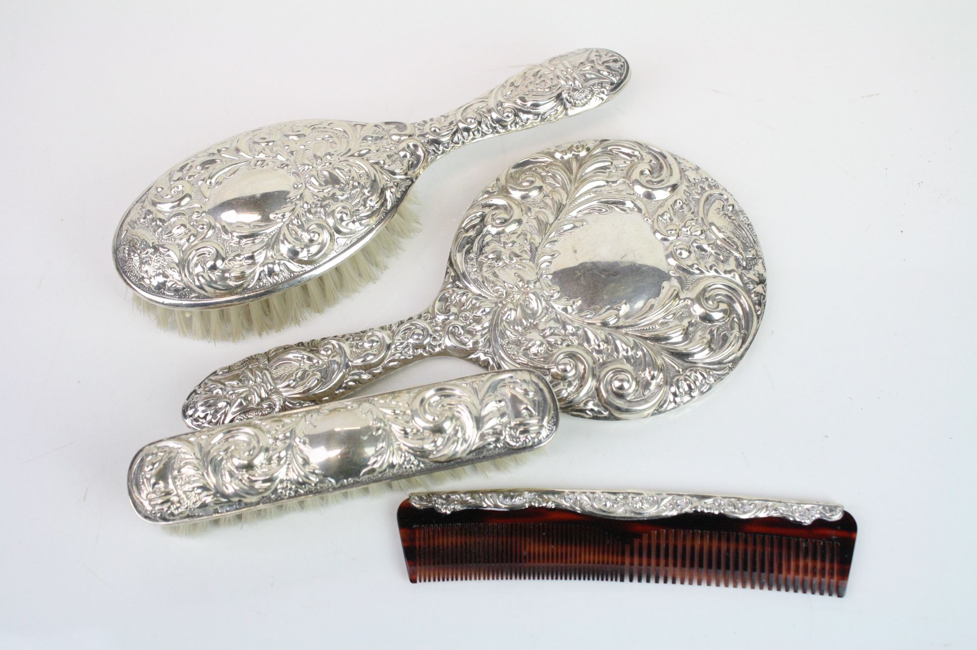 Four piece silver backed dressing table brush set comprising hair brush, hand mirror, comb and