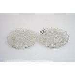 Pair of silver filigree circular dishes raised on three flower head feet, London import marks for