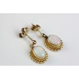 Pair of opal 9ct yellow gold drop earrings, the precious white opal displaying violet, indigo,