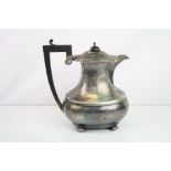 Silver hot water pot raised on four bun feet, waisted form, ebony handle and finial, makers mark