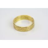 22ct yellow gold wedding band, repeating engraved decoration, band width approx 5mm, ring size N