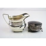 Early 20th century silver milk jug raised on four ball feet, reeded decoration, makers mark