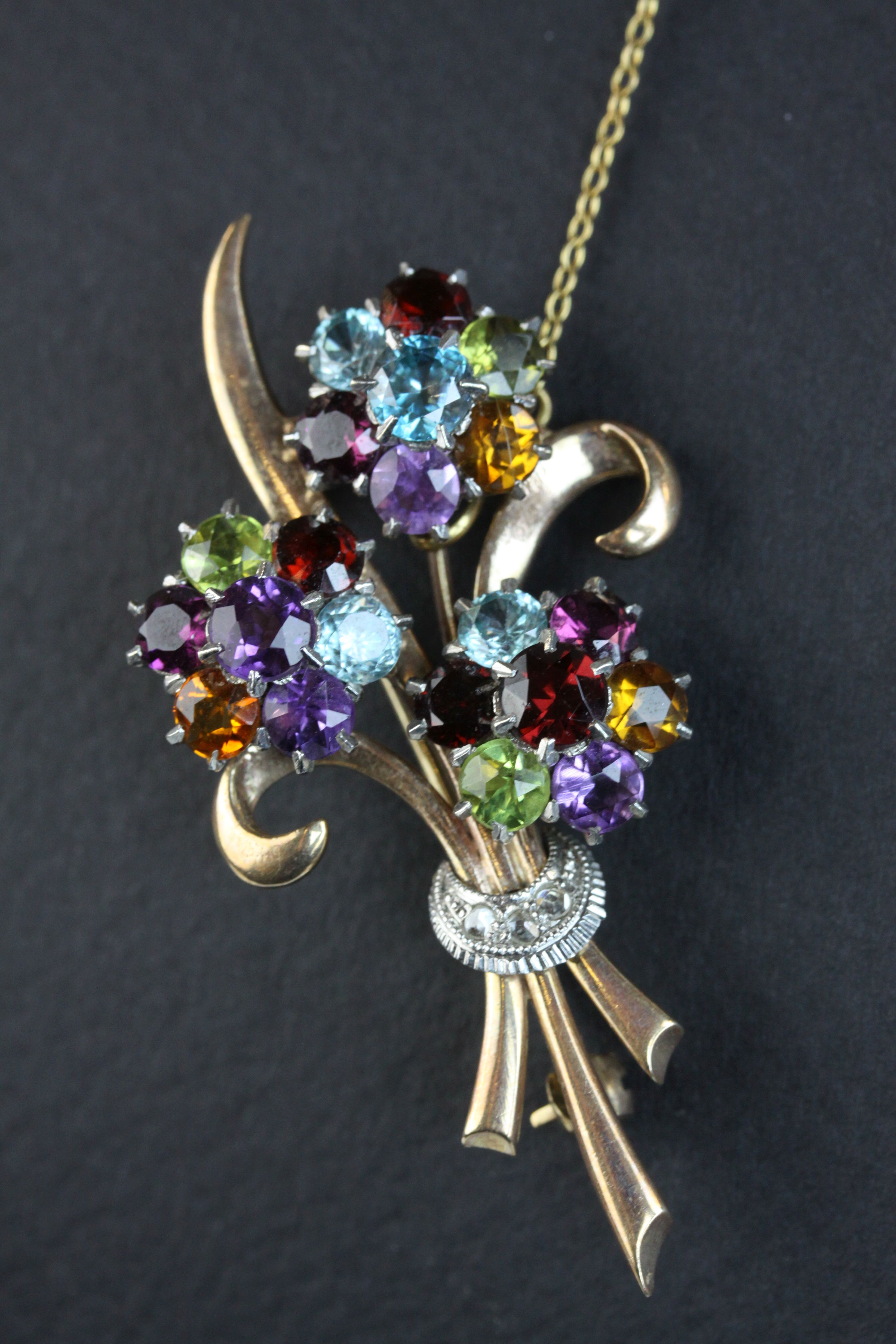 Multi-gemstone 9ct yellow and white gold floral spray brooch, the flower heads set with amethyst,