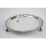 Silver salver raised on three claw and ball feet, gadrooned ogee border, makers Goldsmiths &