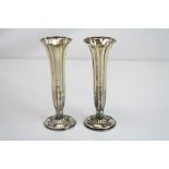 Pair of silver flared posy vases, foliate decoration to lower half in relief, the weighted foot