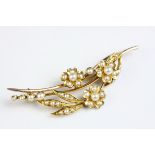 Edwardian seed pearl yellow metal spray brooch, the flower heads and leaves set with graduated