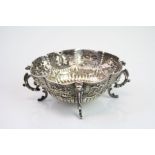 Victorian silver trinket dish raised on four scroll feet, repousse mask, berry and scroll design