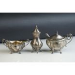 Three piece silver cruet comprising twin handled open oval salt cellar, mustard pot and pepper