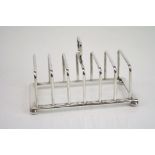 Edward VIII silver seven bar toast rack raised on four bun feet, makers H F Withers, Birmingham