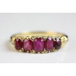 Victorian ruby and diamond yellow metal ring, five graduated oval faceted rubies, the largest