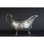 George III Irish silver gravy boat, repousse country farm scene with maiden, cow and buildings,