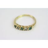 Emerald and diamond five stone 18ct yellow gold ring, three round brilliant cut emeralds and two