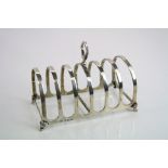 George V silver seven bar toast rack, arched form, raised on four feet, makers Adie Brothers Ltd,