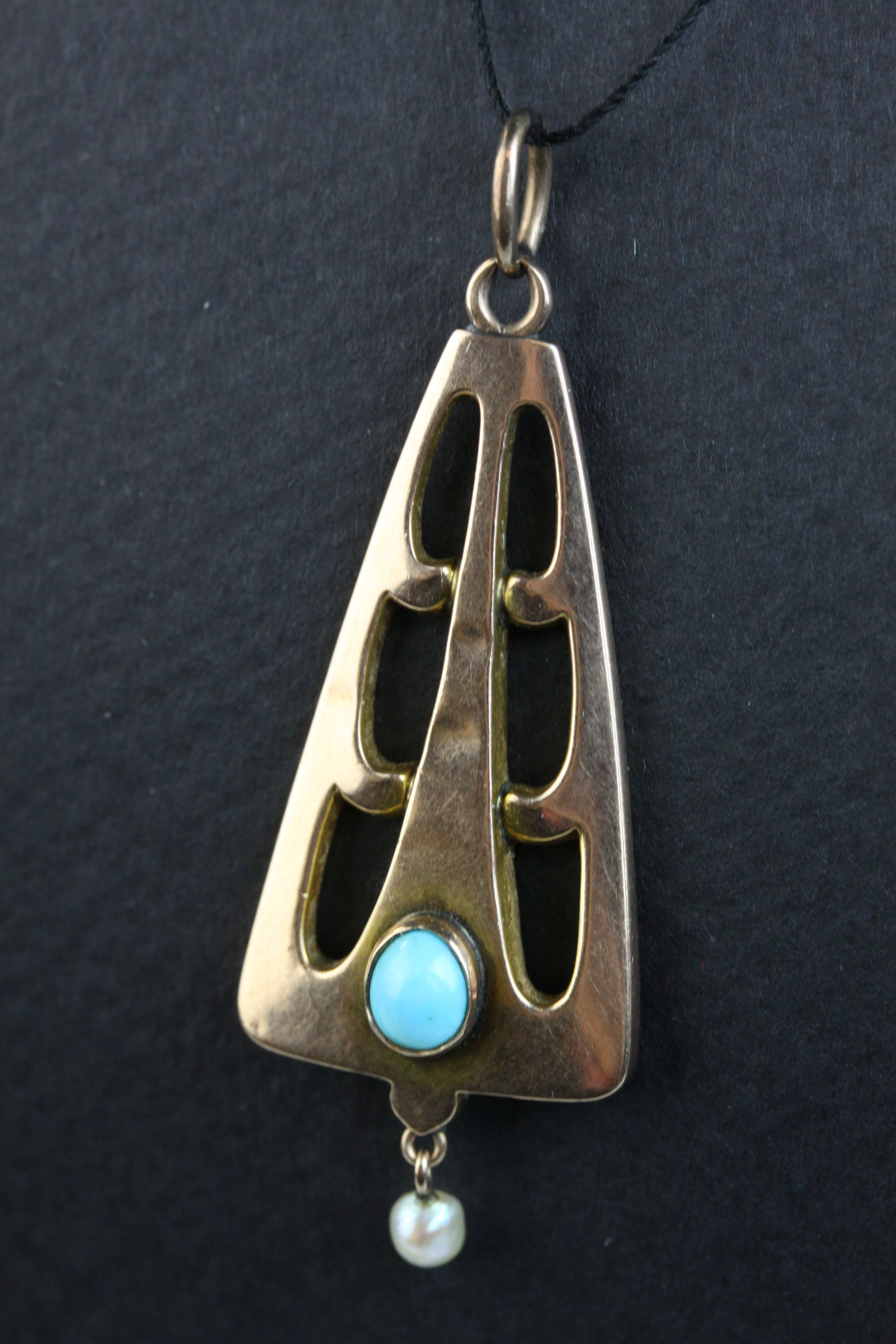 Arts and Crafts turquoise and seed pearl 9ct rose gold pendant, the openwork triangular design frame