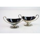 Pair of Victorian silver twin handled pedestal oval salt cellars, plain polished body, reeded