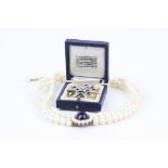 Amethyst and cream cultured pearl three strand necklace, large oval cabochon amethyst to centre
