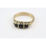 Sapphire and diamond boat head yellow metal ring, three blue-black round faceted sapphire with