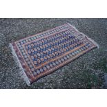 Blue and Cream Ground Wool Rug with an orange and red Bukhara style pattern, 200cms x 128cms