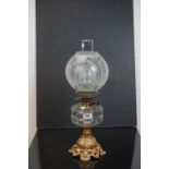 Late 19th / Early 20th century Oil Lamp, the faceted clear glass well raised on a Cast Iron base,