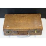 An antique leather suitcase with brass locks.