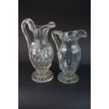 Two 19th Century glass jugs of slender form on raised circular feet