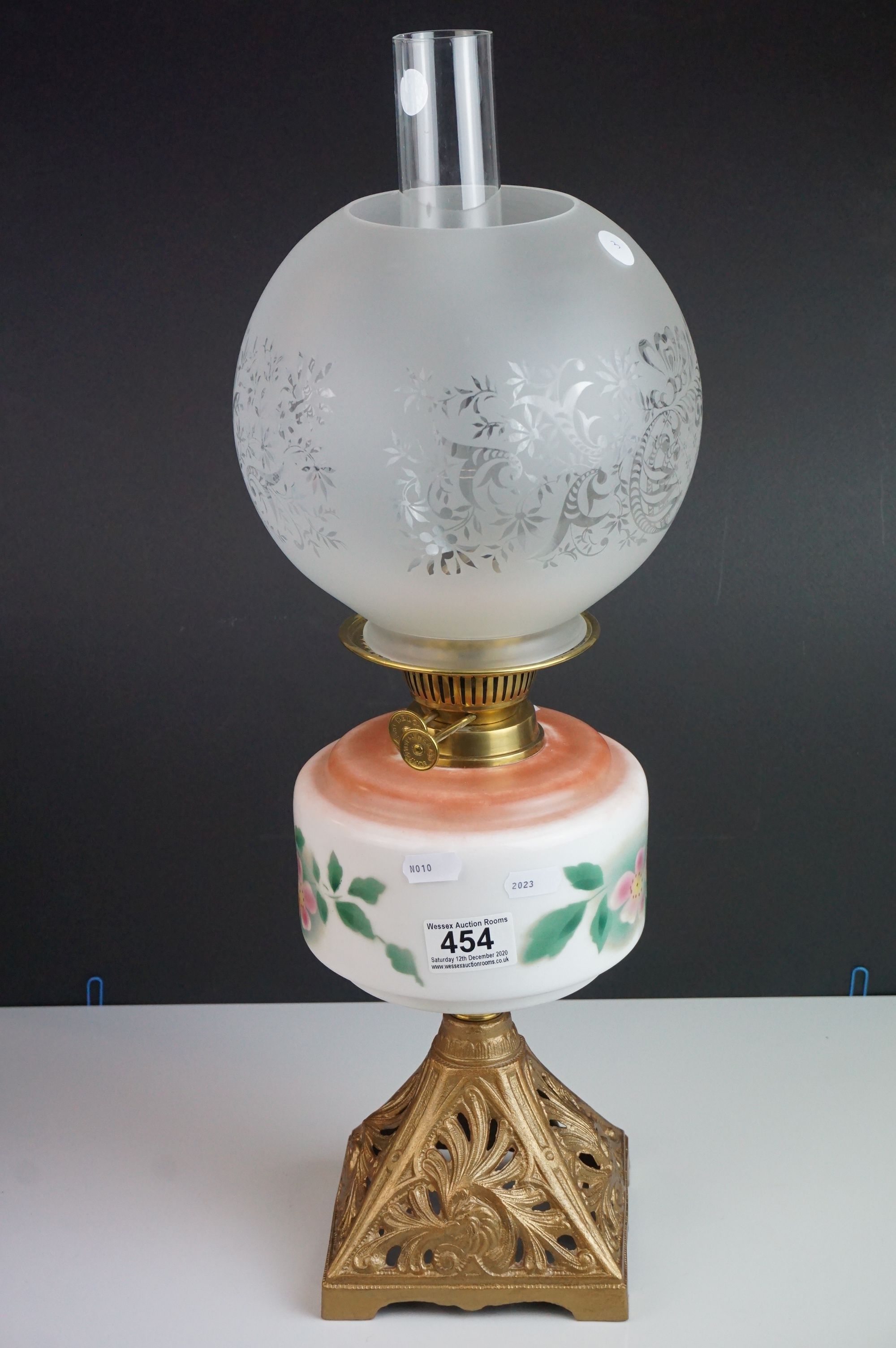 Two antique oil lamps with floral decorated ceramic wells, both with cast iron bases, floral - Image 2 of 9