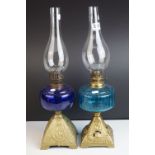 An antique oil lamp with gilt painted cast iron base Blue glass well and chimney and one other