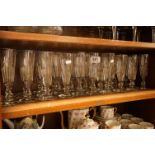 Composite set of thirty glass champagne flutes, all with knopped stems