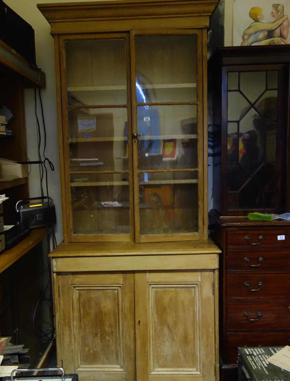 Pine bookcase with twin glazed top section 5'6 tall, base section containing 2 cupboards, 1 door