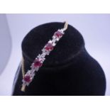 Delicate Ladies 9ct gold diamond and ruby bracelet 7" long, the Gem set section containing 4 x