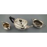 A silver three piece tea service, Sheffield 1912, Cooper Bros., with part gardrooned bodies,, the