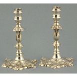 A pair of cast silver tapersticks, London 1975, Barnards, foliate cased hexagonal bases and