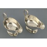 A pair of silver sauce boats, Sheffield 1926, William Hutton, with leaf cast handles and raised on