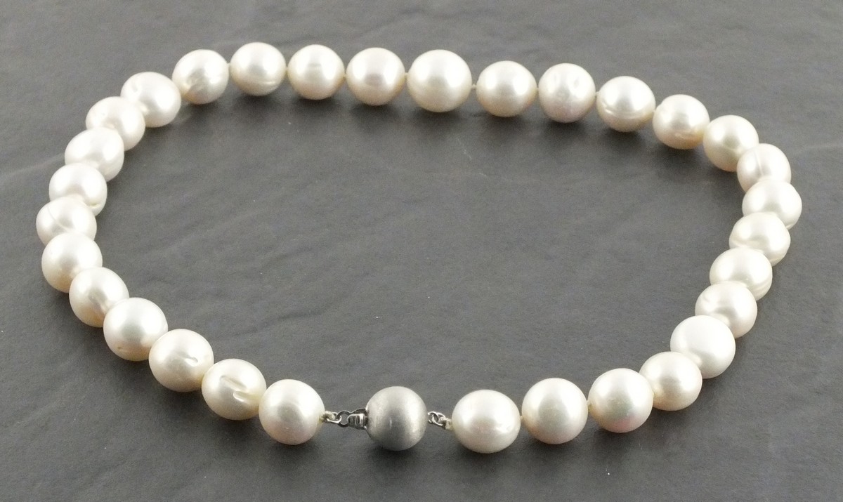 A string of cultured pearls with a 9ct white gold satin effect ball clasp