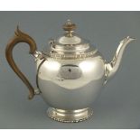 A silver teapot, London 1929, Edward Barnard & Sons, with bobbin and reed borders, and fruitwood