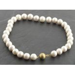 A string of cultured pearls with a 9ct yellow gold satin effect ball clasp