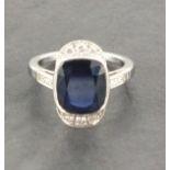 An 18ct white gold cushion sapphire and diamond art deco style cluster ring with diamond
