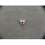 An 18ct yellow gold oval ruby and diamond cluster ring, ruby 2.25ct, diamonds 1.50ct