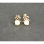 A pair of pearl earrings with diamond bow tops