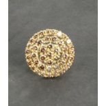 A diamond cluster ring, of circular plaque form, the untreated champagne coloured stones totalling