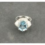 A large aquamarine and diamond set dress ring,  the oval central stone approx. 5.05ct, with a